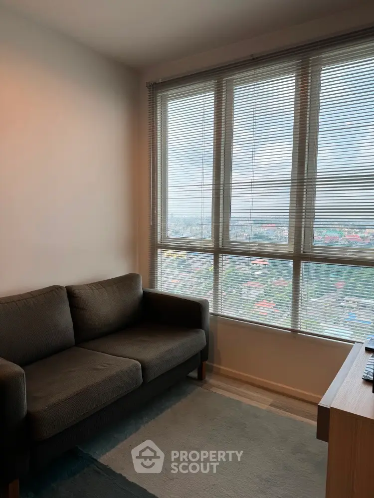 Cozy living room with large window offering stunning city view