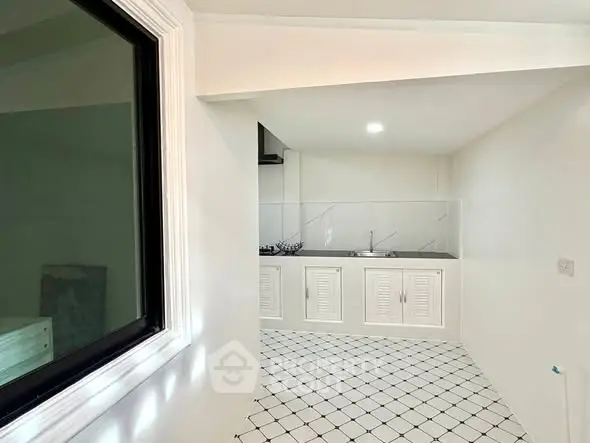 Modern kitchen with sleek white cabinetry and checkered tile flooring