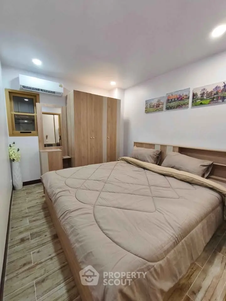 Cozy bedroom with modern decor and wooden flooring, featuring a large bed and stylish wardrobe.