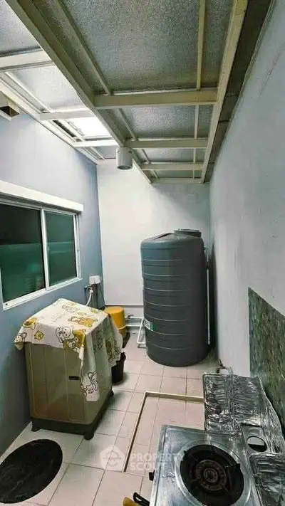 Compact utility area with water tank and gas stove in modern home