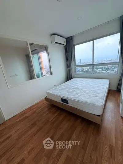 Spacious bedroom with large window offering stunning city views, featuring a comfortable bed and modern air conditioning.