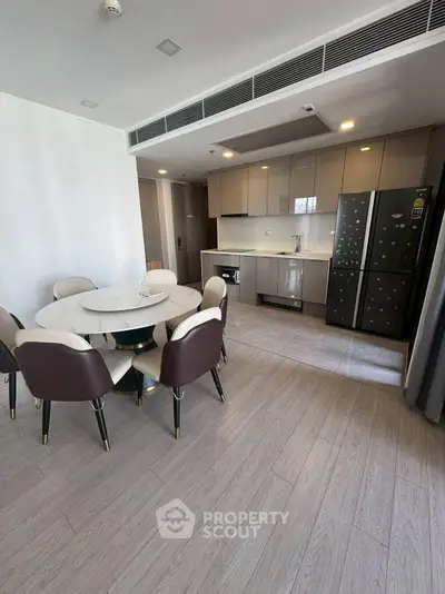 Modern kitchen with sleek cabinetry and dining area in open layout apartment.
