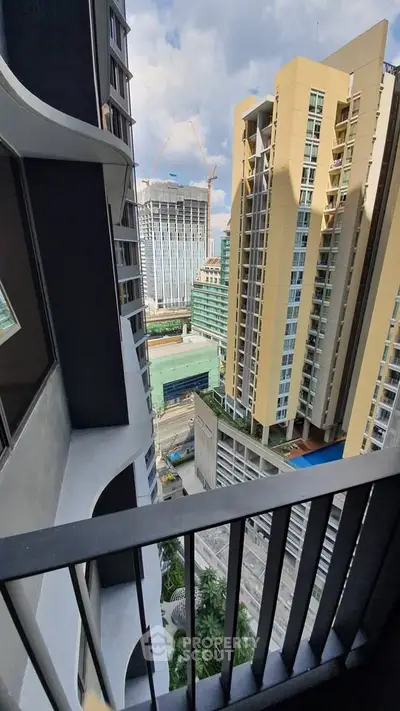 Stunning high-rise balcony view of modern cityscape with towering buildings and construction cranes.