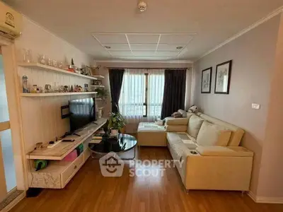 Cozy living room with modern decor and natural light, featuring a comfortable sofa and entertainment center.