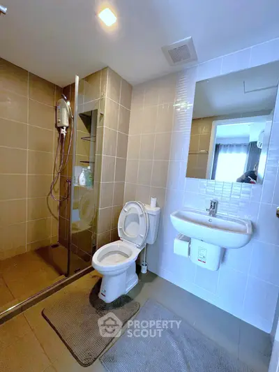 Modern bathroom with glass shower and sleek fixtures in a contemporary apartment.