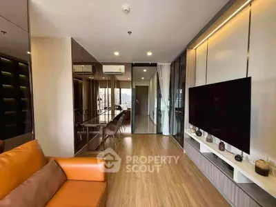 Modern living room with sleek design, large TV, and stylish furniture in a contemporary apartment.