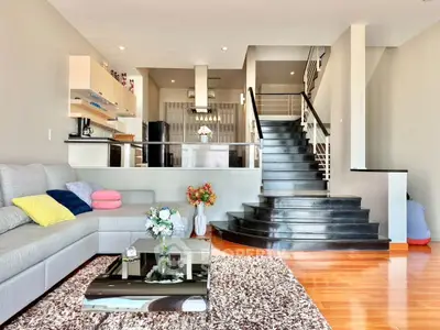 Spacious modern living room with stylish staircase and open kitchen layout