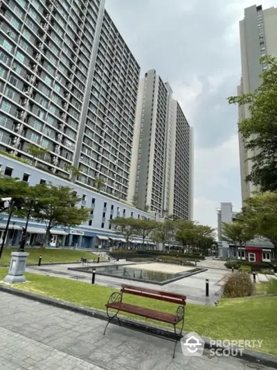 Modern high-rise residential buildings with lush green landscaping and serene courtyard.