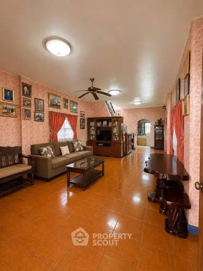 Spacious living room with elegant decor and warm lighting, featuring comfortable seating and stylish furniture.