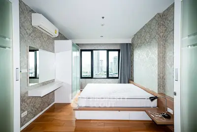 Modern bedroom with city view, featuring elegant wallpaper and wooden flooring.