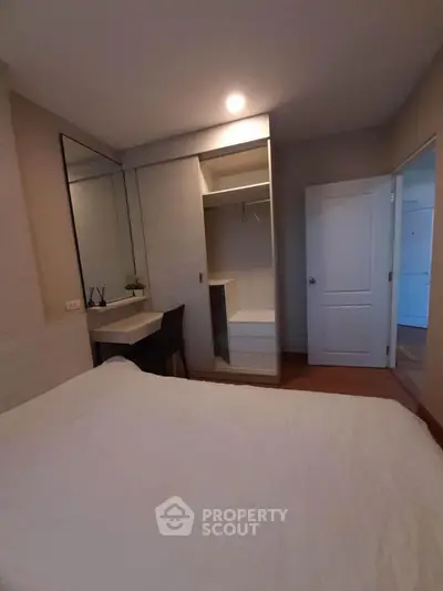 Cozy bedroom with built-in wardrobe and study desk, perfect for modern living.