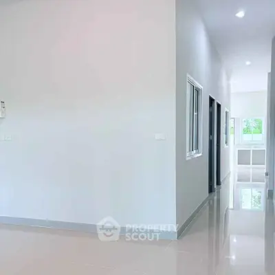 Spacious modern hallway with glossy tiled floors and natural light.