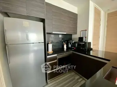 Modern kitchen with sleek cabinetry and stainless steel appliances in a stylish apartment.