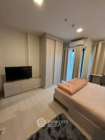 Modern bedroom with cozy decor, featuring a bed, TV, and wardrobe, perfect for comfortable living.