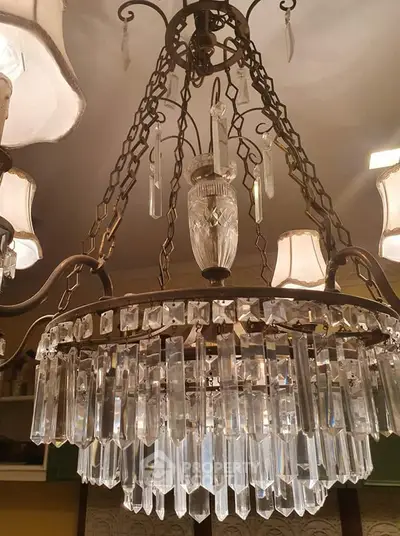 Elegant vintage chandelier with crystal prisms in a luxurious interior setting.