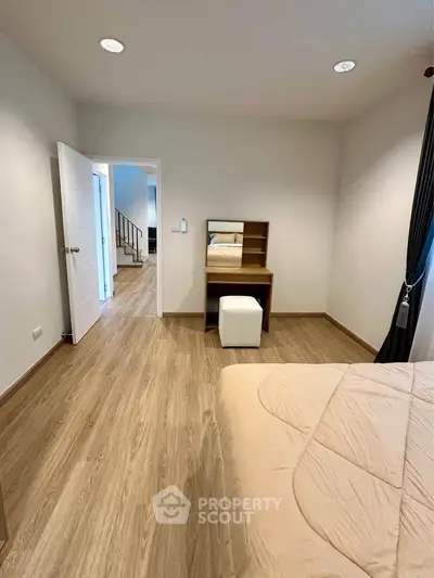 Cozy bedroom with wooden flooring and modern furniture, perfect for relaxation.