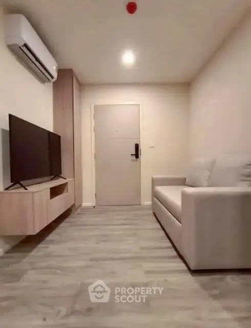 Modern living room with sleek design, featuring a comfortable sofa and wall-mounted TV unit.