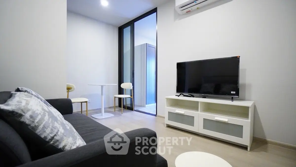 Modern living room with sleek furniture and flat-screen TV, perfect for relaxation.