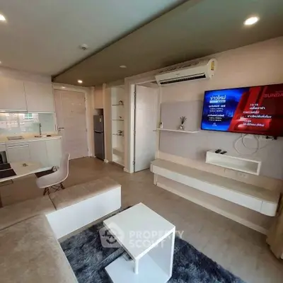Modern living room with sleek furniture and wall-mounted TV in a cozy apartment.