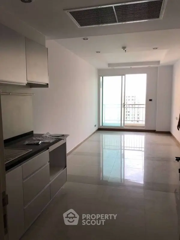 Modern apartment interior with sleek kitchen and balcony view