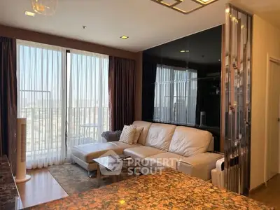 Modern living room with large windows and stylish decor in a high-rise apartment.