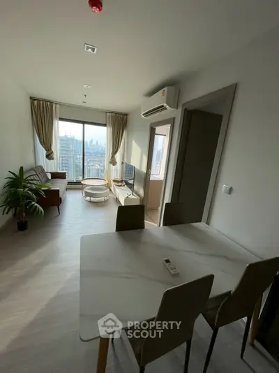 Modern living room with city view, stylish furniture, and natural light.