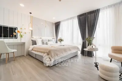 Luxurious modern bedroom with elegant decor and large windows offering abundant natural light.