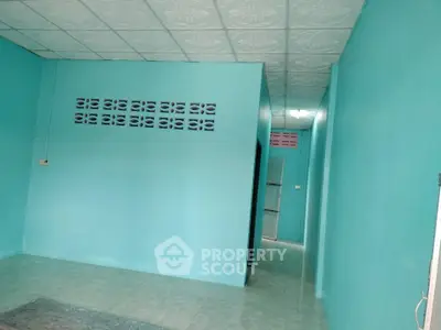 Spacious turquoise interior with tiled ceiling and floor, ideal for creative renovation.