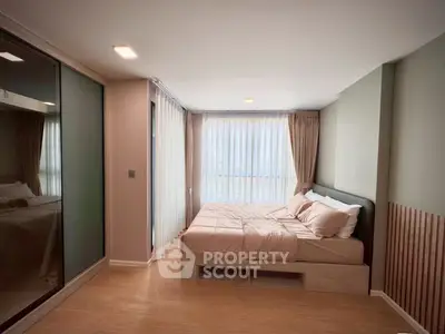 Modern bedroom with large windows and stylish decor in a contemporary apartment.