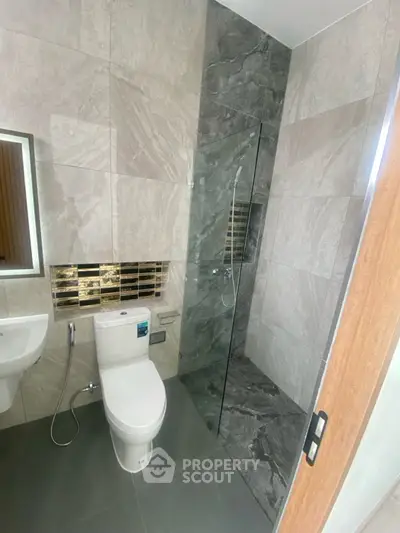 Modern bathroom with sleek design, glass shower, and stylish tiles.