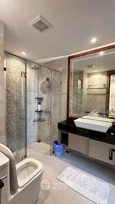 Luxurious modern bathroom with glass shower and elegant vanity in upscale property.