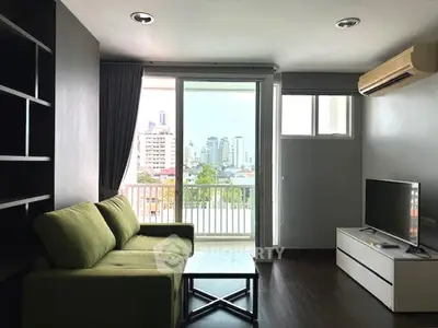 Modern living room with green sofa, city view, and balcony access.