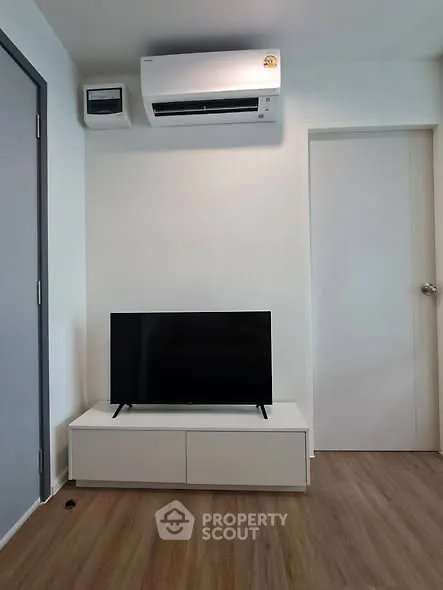 Modern living room with sleek TV setup and air conditioning unit