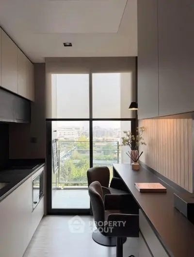 Modern kitchen with sleek design and balcony view, featuring minimalist decor and natural light.