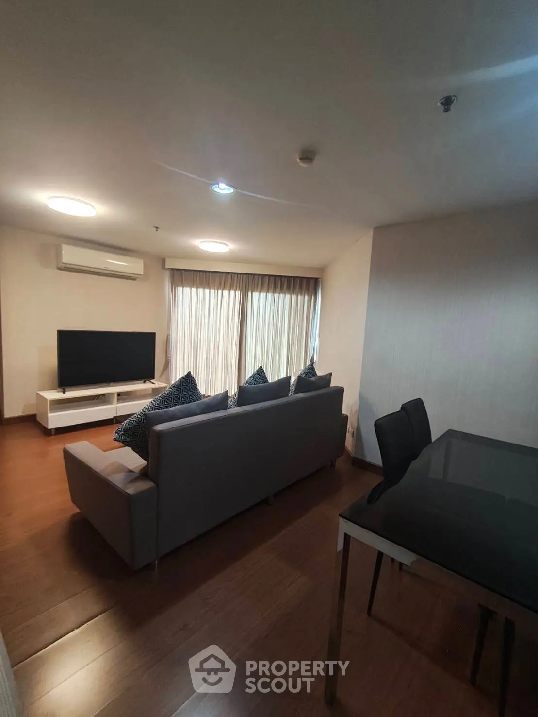 Modern living room with sleek furniture and large TV, perfect for relaxation and entertainment.