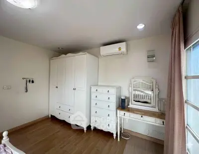 Charming bedroom with elegant white furniture and natural light, perfect for a cozy retreat.