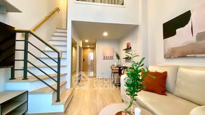 Modern duplex living room with stylish decor and open staircase