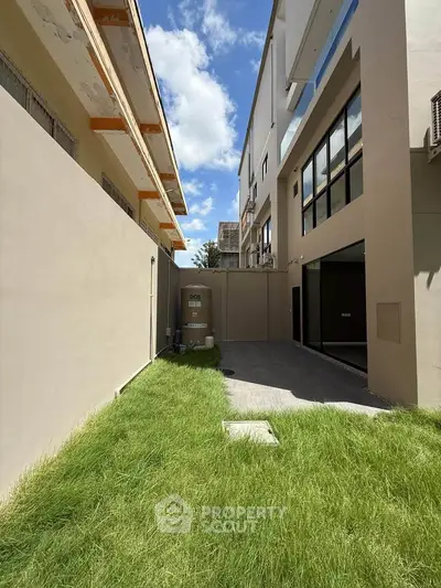 Modern building exterior with lush green lawn and clear blue sky