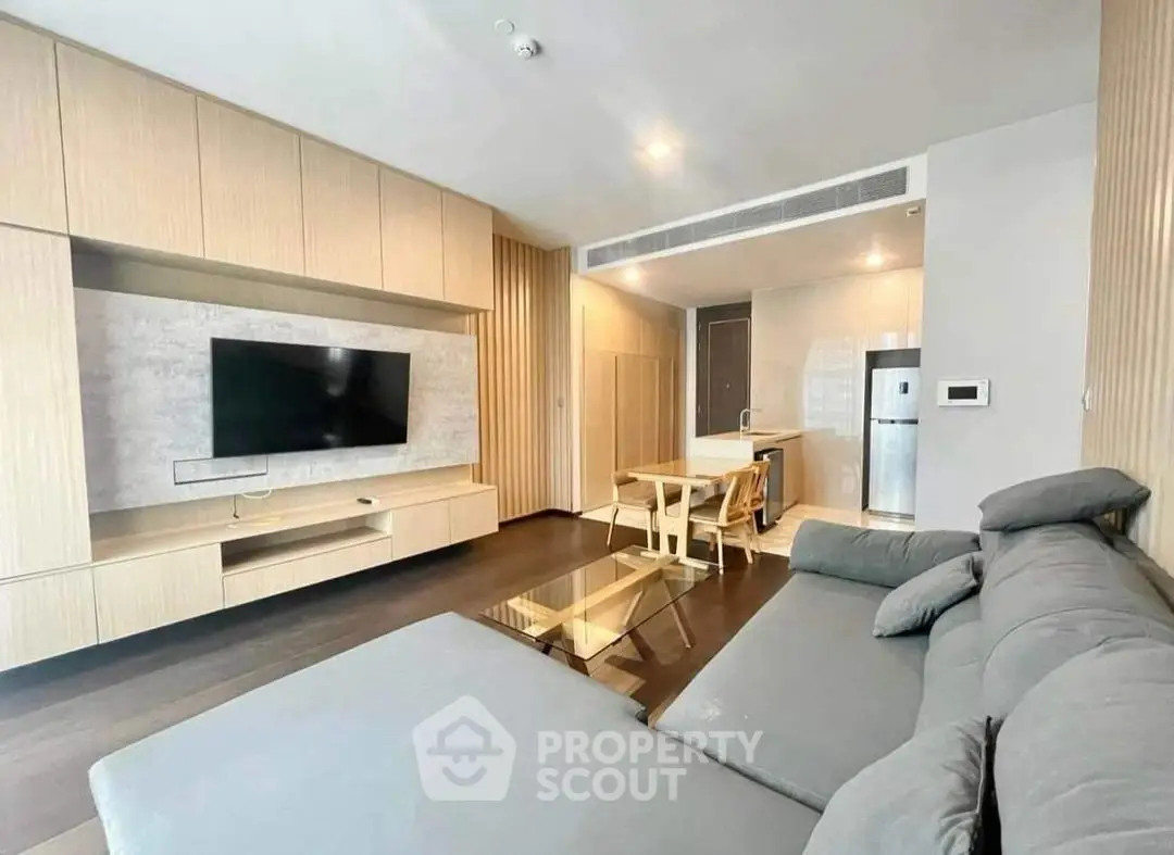 Modern living room with sleek furniture and open kitchen layout in a stylish apartment.