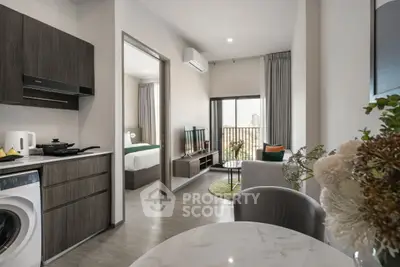 Modern apartment interior with open kitchen and living area, featuring sleek design and natural light.