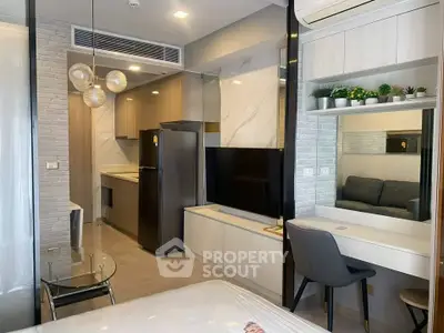 Modern studio apartment with sleek kitchen and cozy living area, featuring stylish decor and ample natural light.