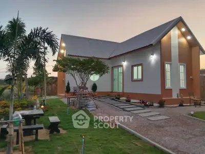 Charming modern house with lush garden and pathway at sunset, perfect for serene living.