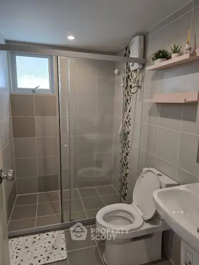Modern bathroom with glass shower, sleek tiles, and contemporary fixtures.