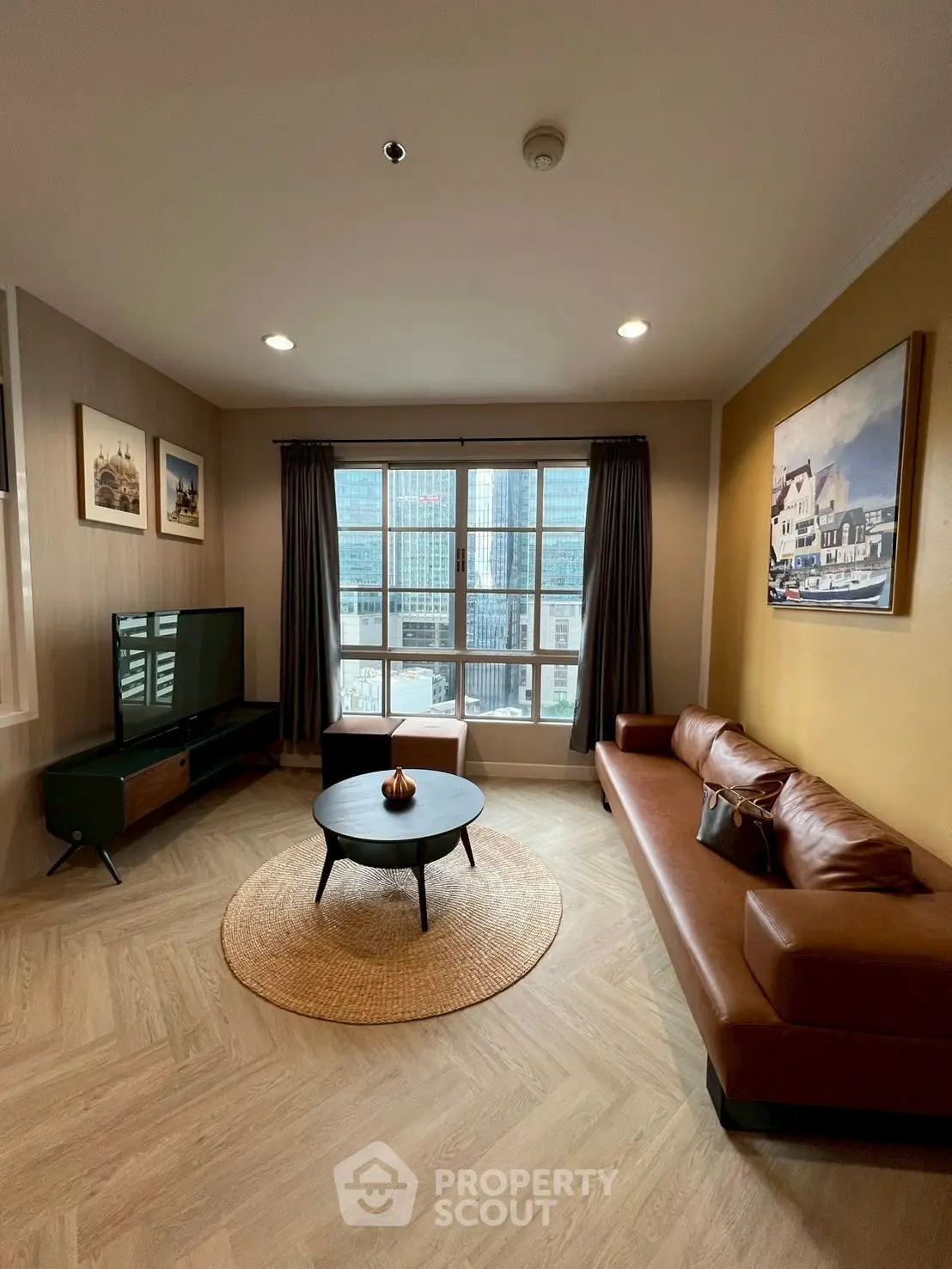 Stylish living room with leather sofa and city view, perfect for modern urban living.