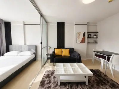 Modern studio apartment with open layout, featuring a cozy living area and stylish bedroom.