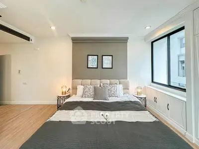 Spacious bedroom with elegant decor and large window for natural light