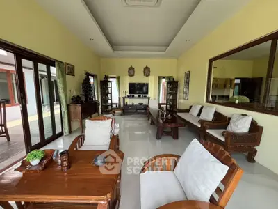 Spacious living room with elegant wooden furniture and large windows offering natural light.
