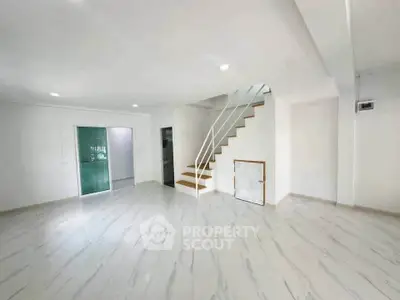 Spacious modern living room with sleek staircase and marble flooring