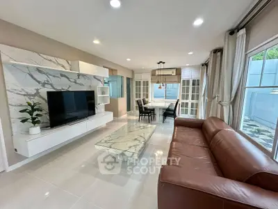 Spacious modern living room with marble accents and large windows.