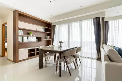 Modern dining area with elegant furniture and large windows offering natural light in a stylish apartment.